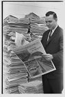 Man with a large stack of The Daily Reflector 